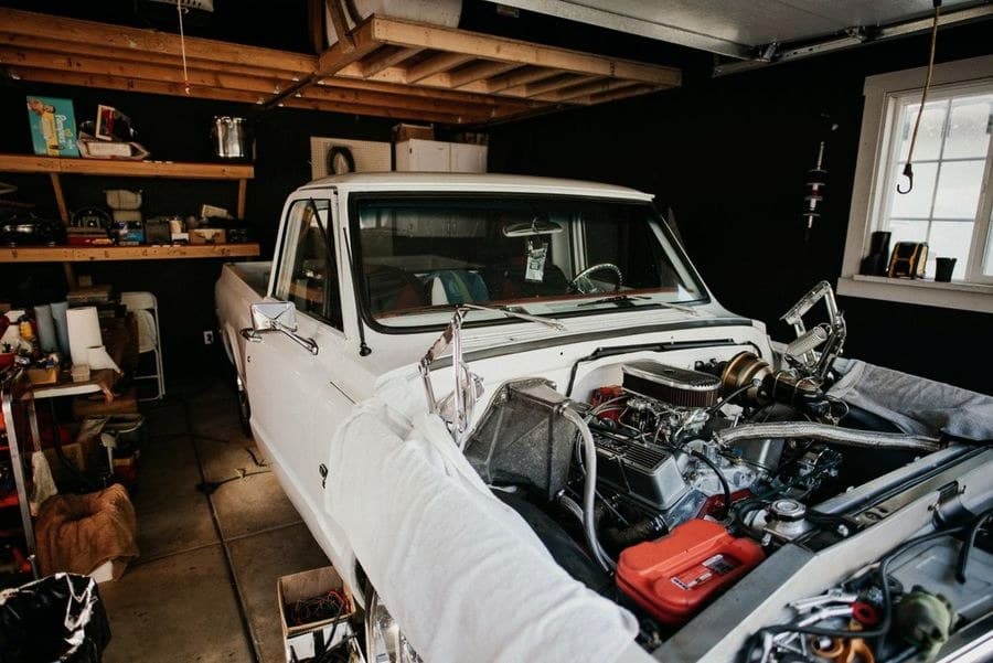 Classic pickup truck with the hood up, mid-repair